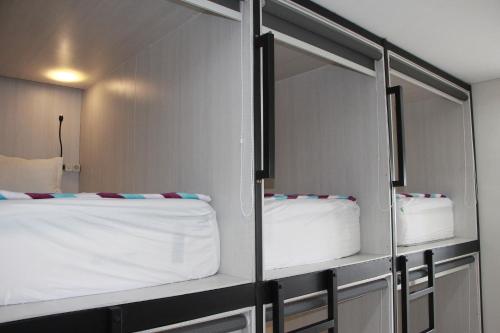 a room with two beds and a mirror at The Peak Guest House in Jember
