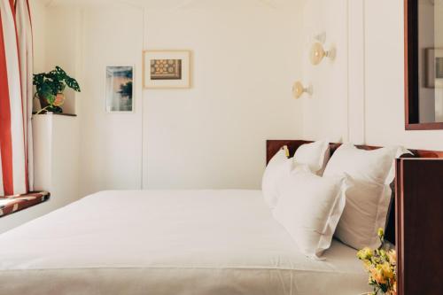 a bedroom with a white bed with white pillows at Hôtel Wallace - Orso Hotels in Paris