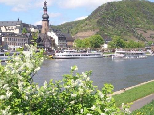 a river with boats on the water in a town at Ferienweingut Stein in Valwig