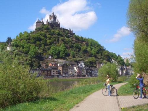 two people riding bikes on a path in front of a hill at Ferienweingut Stein in Valwig