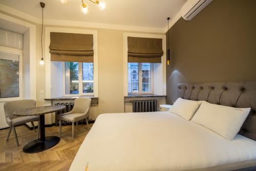 a bedroom with a bed and a table and chairs at DayFlat Apartments Maidan Area in Kyiv
