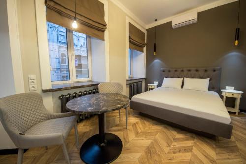 a bedroom with a bed and a table and chairs at DayFlat Apartments Maidan Area in Kyiv