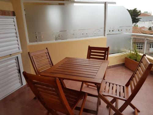una mesa y sillas de madera en un balcón en el Apart Agustina de Villa Gesell