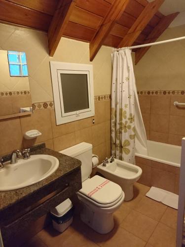 een badkamer met een wastafel, een toilet en een badkuip bij Apart Agustina in Villa Gesell