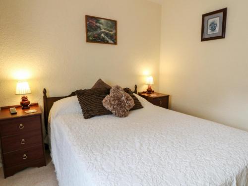 a bedroom with a bed with two nightstands and two lamps at Summerfields in Uttoxeter