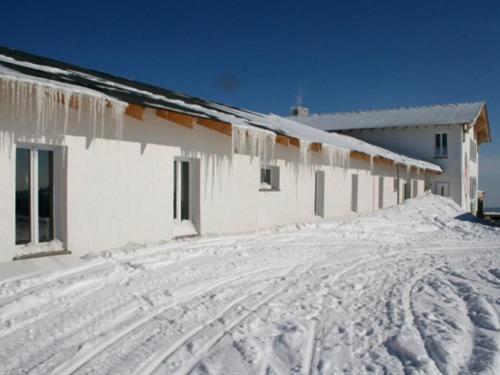 un edificio cubierto de nieve con carámbanos. en Fichtelberghütte, en Kurort Oberwiesenthal