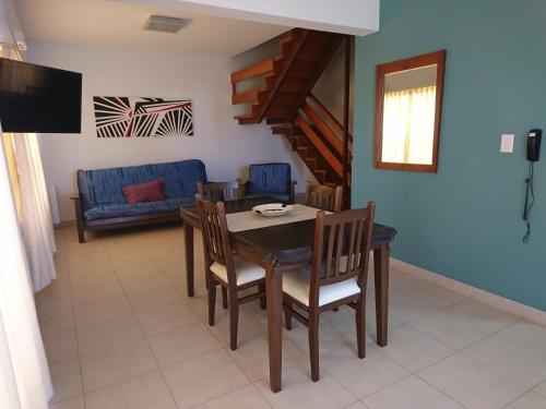 uma sala de jantar com uma mesa e cadeiras e um sofá em Apart Agustina em Villa Gesell
