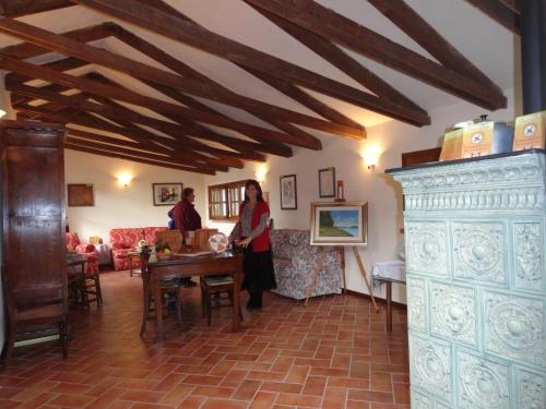 a woman standing in a living room with a table at Agriturismo Santa Maria Bressanoro in Castelleone