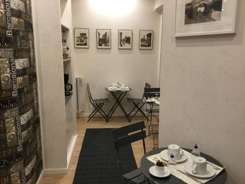 uma sala de jantar com duas mesas e uma mesa e cadeiras em LE FATE SUITES em Roma