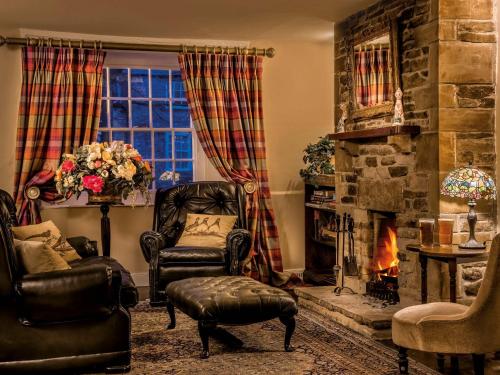 a living room with a chair and a fireplace at The Fauconberg in Coxwold