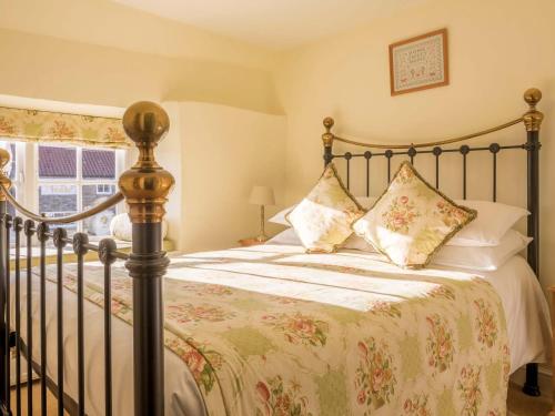 a bedroom with a bed with a bedspread and pillows at The Fauconberg in Coxwold
