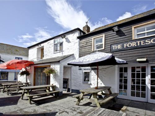 a group of picnic tables in front of a building at The Fortescue Inn Salcombe in Salcombe