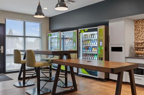 a restaurant with a table and chairs and a refrigerator at Extended Stay America Premier Suites - Melbourne - Palm Bay in West Melbourne