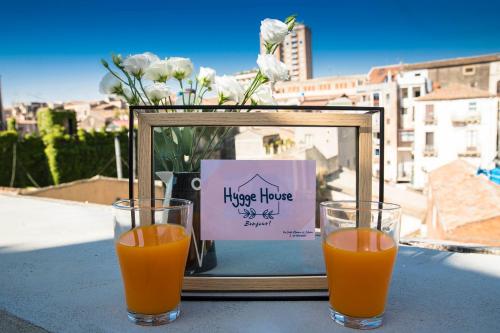Hygge House Catania في كاتانيا: كأسين من عصير البرتقال على طاولة مع صورة