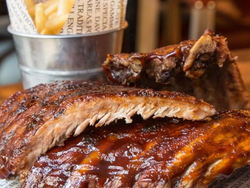 a close up of two pieces of meat and french fries at The Fitzrovia Belle Hotel in London