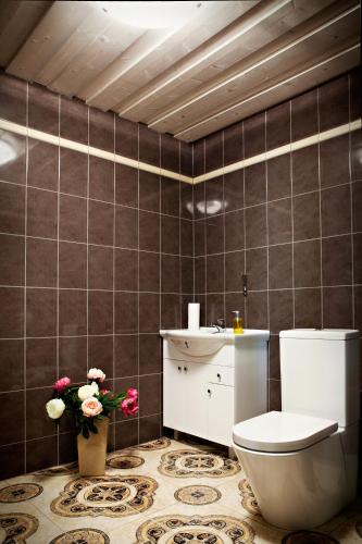 a bathroom with a toilet and a sink and flowers at Hämsa Maheresto & Heaolukeskus in Võru