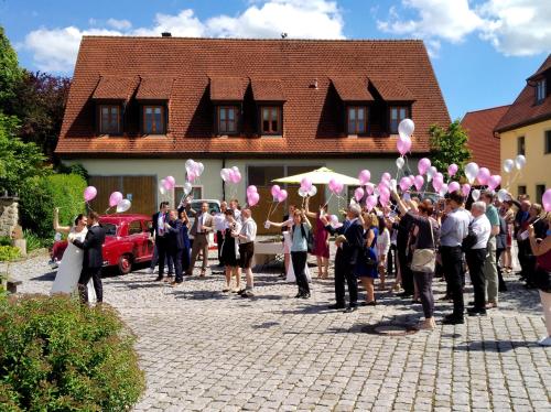 a group of people are holding pink balloons at Gasthaus Dollinger in Dinkelsbühl