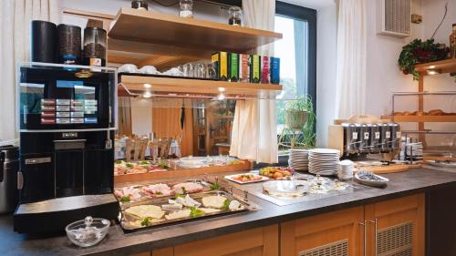 una cocina con muchos platos de comida en una barra en Gasthof Hotel Anker, en Sommerhausen