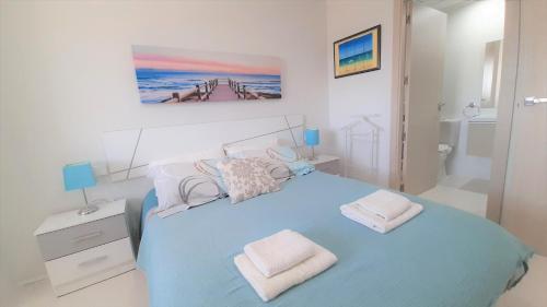 a bedroom with a blue bed with two towels on it at La Belle bleue in La Marina