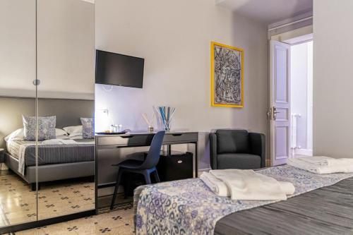 1 dormitorio con escritorio, 1 cama y 1 silla en Re Vittorio De Luxe, en Messina