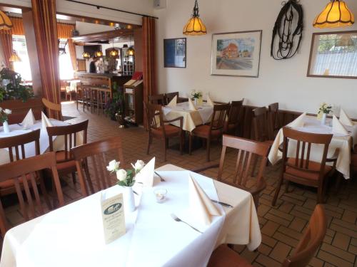 een eetkamer met tafels en stoelen en een restaurant bij Hotel Geschermann in Sendenhorst