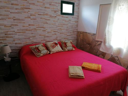 - une chambre avec un grand lit et une couverture rouge dans l'établissement Piccola Dependance, à Syracuse