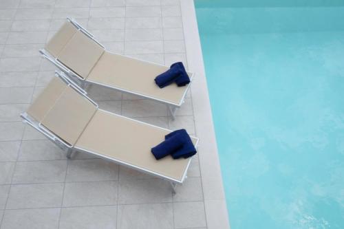 two blue seats on a shelf next to a pool at Hotel B&B Fortuna in Costermano sul Garda