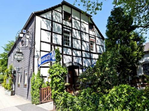 een wit en zwart gebouw met een bord erop bij Hotel Haus Gimken in Essen