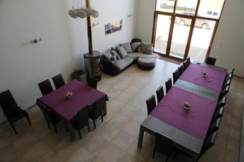 - un salon avec des tables violettes et un canapé dans l'établissement gite du baraquet, à La Vèze