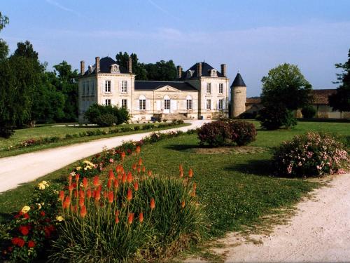 una casa grande con flores delante en La France - Gite Chateau, en Beychac-et-Caillau