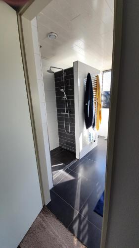 a bathroom with a shower with a black tile floor at Logies bij Wandelpad te Holten in Holten