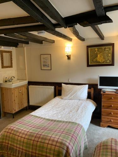 a bedroom with a bed and a sink at Borderers Inn in Brecon