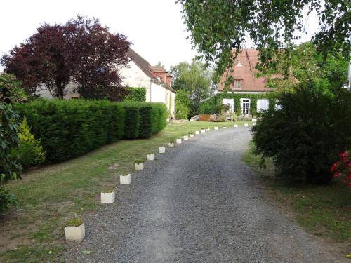 una carretera en un patio con arbustos y una casa en Gites de Gondieres, en Saint-Éloi