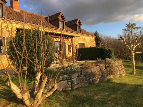 een stenen huis met een stenen muur in de tuin bij Gites La Source in Le Calet