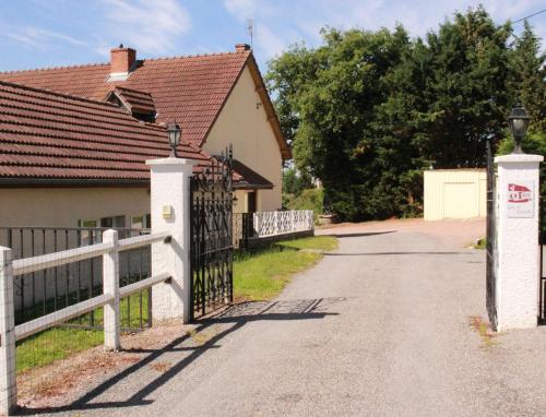 einen Zaun vor einem Haus mit Auffahrt in der Unterkunft Gites de Montvaltin in Le Breuil