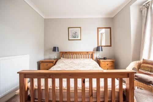 ein Schlafzimmer mit einem Holzbett und einem Sofa in der Unterkunft Glendower B&B in St. Davids