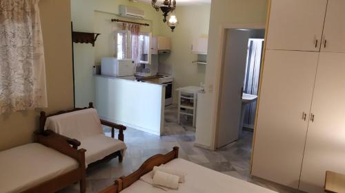 ein Wohnzimmer mit einem Sofa und Stühlen sowie eine Küche in der Unterkunft Grivas Apartments in Syvota