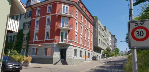 easyHotel Zürich West في زيورخ: مبنى احمر وبيض على جانب شارع