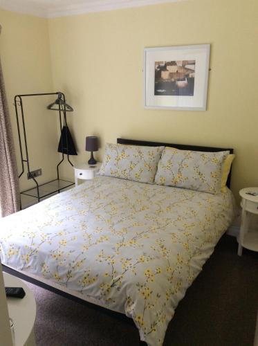 a bedroom with a bed with yellow flowers on it at 9 The Net Lofts in Mevagissey