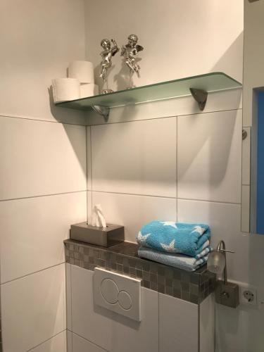 a bathroom with a shelf on the wall with towels at Apartment Klatenberg in Telgte