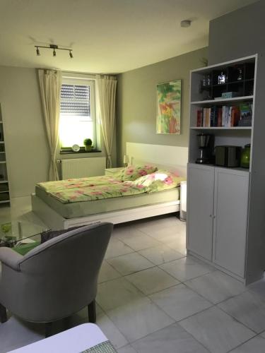 a bedroom with a bed and a table and a chair at Apartment Klatenberg in Telgte