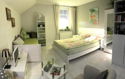a bedroom with a bed and a living room at Apartment Klatenberg in Telgte