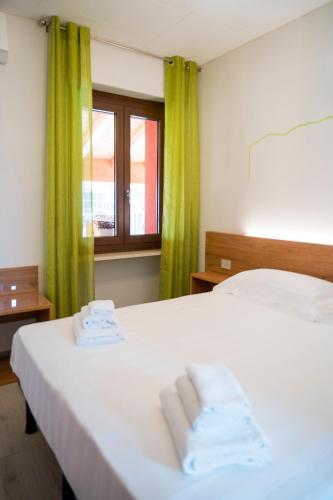 a bedroom with a white bed with two towels on it at Vino e Turismo in San Defedente di Cervasca