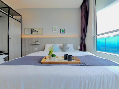 a bedroom with a bed with a tray on it at The Wave Suites Melaka in Melaka