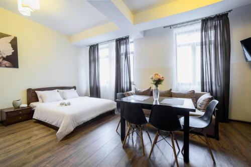una camera con letto, tavolo e sedie di Aparthotel Na Mytniy a Lviv