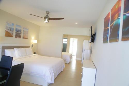 a hotel room with a white bed and a desk at Diane Oceanfront Suites in Hollywood