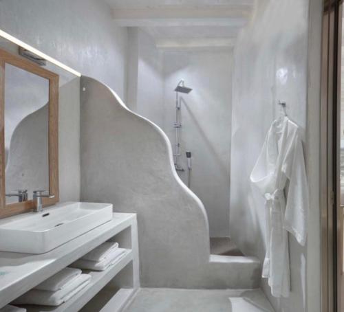 Crystal Suites في مدينة ميكونوس: حمام أبيض مع حوض ومرآة