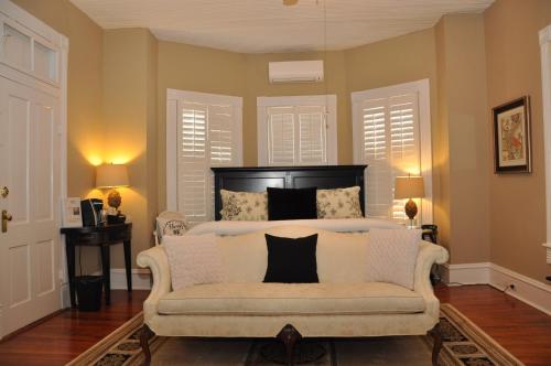 een slaapkamer met een bed en een bank met kussens bij Trowell Historic Inn in Jesup