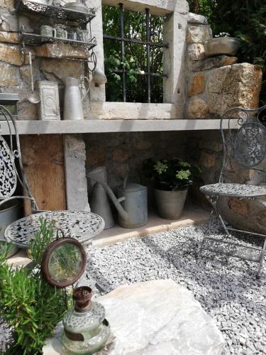 a stone wall with a shelf with plants and a mirror at MAPLE place in Pivka