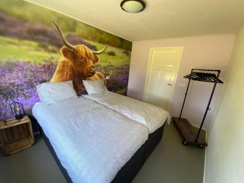 un dormitorio con una pintura de un toro en la pared en Appartement Duinweg en Onstwedde